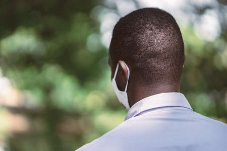 Back of african man wearing face maskの写真素材