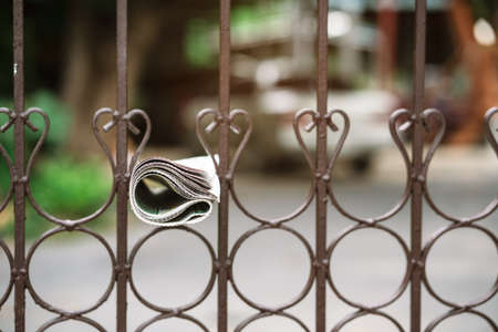 Delivery of a newspaper hang on the fenceの写真素材
