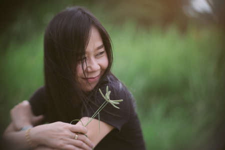 Happy asian woman sitting outdoors with relax and smileの写真素材