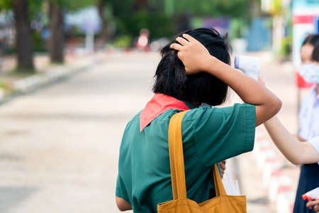 Infrared thermometer gun forehead temperature test to check student for protect virus covid-19 symptoms in the schoolの写真素材