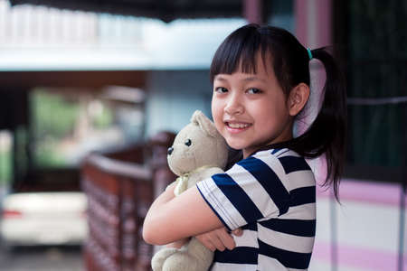 Smile little child girl holding teddy bear with loveの写真素材