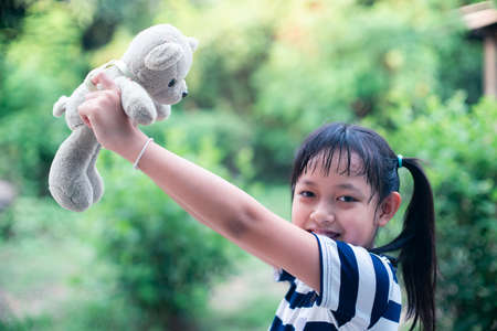 Smile little child girl holding teddy bear with loveの写真素材