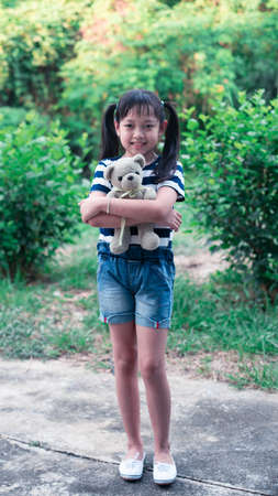 Smile little child girl holding teddy bear with loveの写真素材