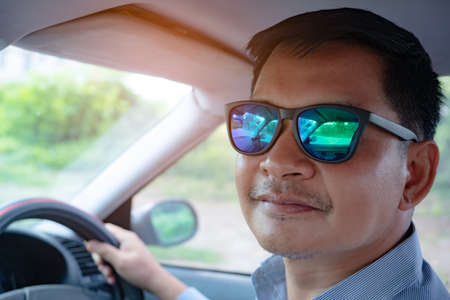 Man driving in the car with wearing sunglassesの写真素材