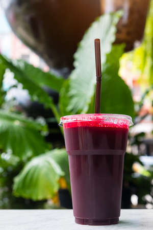 Fresh beet juice in glass on the table with green nature backgroundの写真素材