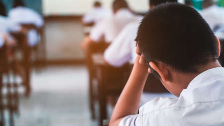 Tired uniform student sleeping in a exam test classroom.16:9 styleの写真素材