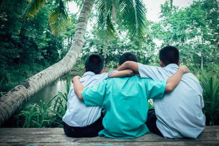 Back view of three students friends hugging with love.Concept of best  friendshipの写真素材