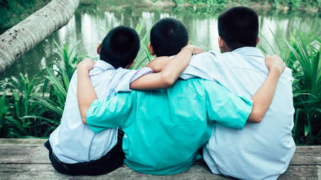 Back view of three students friends hugging with love.Concept of best  friendshipの写真素材