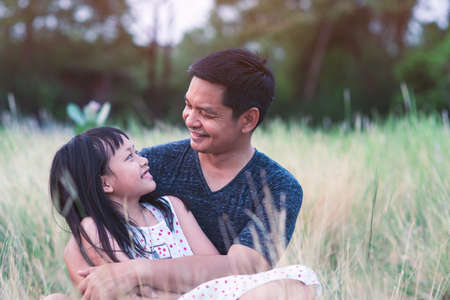 Father and daughter hugging in the green nature with loveの写真素材