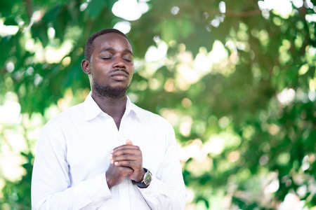 African man praying for thank god in the green natureの写真素材