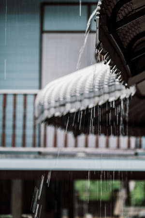 The rain drop flows down from a roof of houseの写真素材