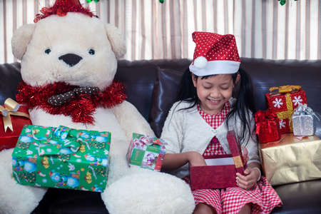 Christmas or Xmas Festive Concept.Asian little girl smile and open a gift box at homeの写真素材
