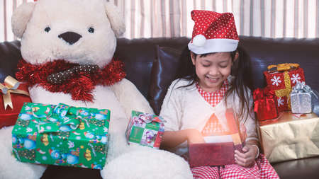 Asian little girl open a gift box with smile and happy in christmas day.16:9 styleの写真素材