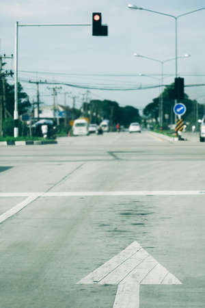 White arrow symbol on on crossroad with red traffic lightの写真素材