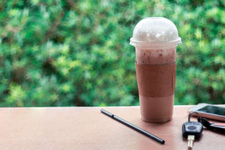 Ice coffee , Key and smartphone in cafe.の写真素材