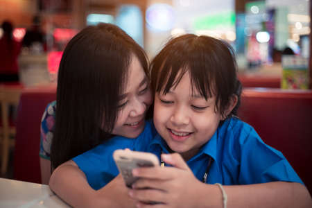 Daughter and mother looking a smart phone with smile and happy
