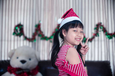 Portrait of smile little child girl in a Christmas hatの写真素材