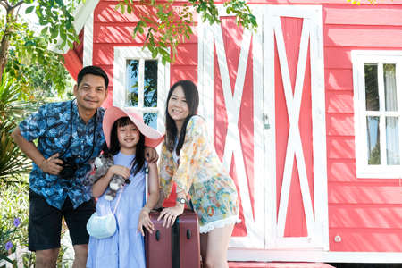 Asian family traveling and  standing near a hotel resort with smile and happyの写真素材