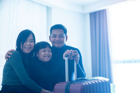 Happy asian family  sitting and smiling at the room in hotelの写真素材