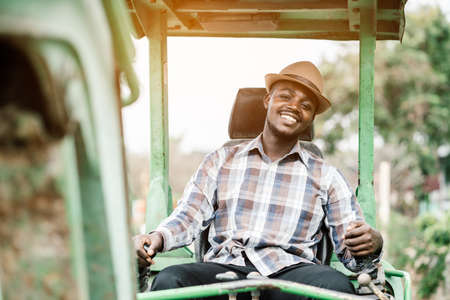 African worker driving heavy construction equipment backhoe with smile and happyの写真素材