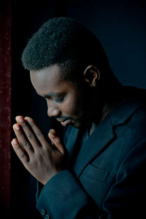African man praying for god in dark room.Low key styleの写真素材
