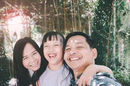 Happy asian family taking selfie in the parkの写真素材