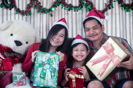 Happy asian family holding a gift box in christmas dayの写真素材