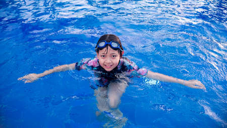 Pretty little girl in swimming pool with smile and happy in summertime.16:9 styleの写真素材