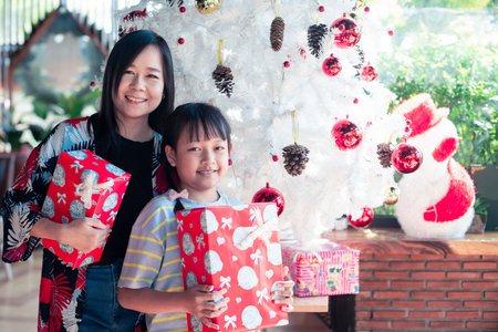 Asian mother and daughter holding a gift box in christmas dayの写真素材