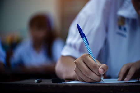 Students taking exam with stress in school classroomの写真素材