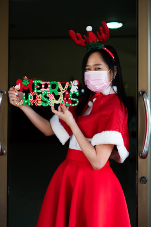 Woman in Santa Claus suit with wearing face mask  in christmas dayの写真素材