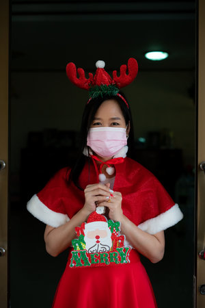 Woman in Santa Claus suit with wearing face mask  in christmas dayの写真素材