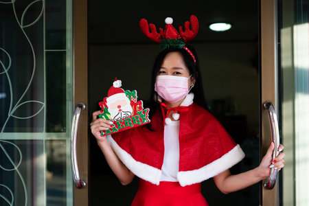 Woman in Santa Claus suit with wearing face mask  in christmas dayの写真素材
