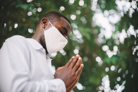 African man praying for god with wearing face maskの写真素材