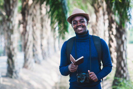 African traveler man holding camera and  passport with smile and happyの写真素材