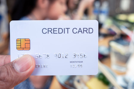 Hand holding a credit cards at restaurantの写真素材