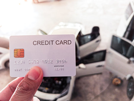 Hand holding a credit cards at auto repair shopの写真素材