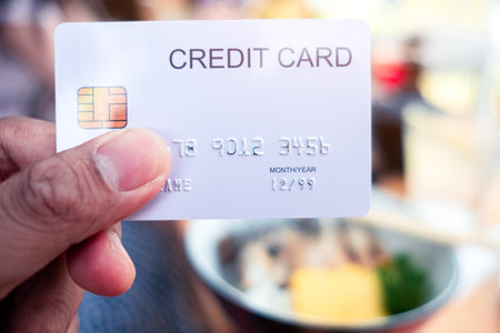 Hand holding a credit cards at restaurantの写真素材