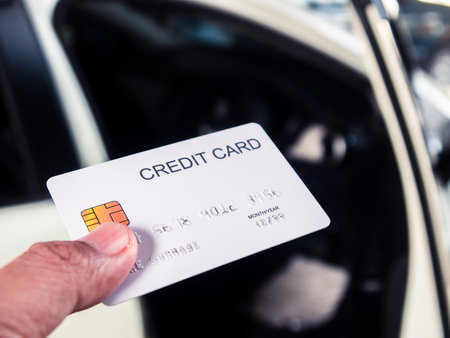 Hands holding a credit card for buying new carの写真素材