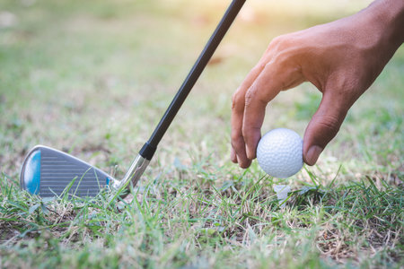 The golf player putting golf ball on tee against with a golf clubの写真素材