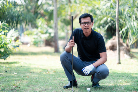 Golf player looking and sitting on field for playing golf on course teeの写真素材