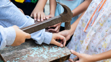 The childens is repairing wooden with a nails and hammerの写真素材