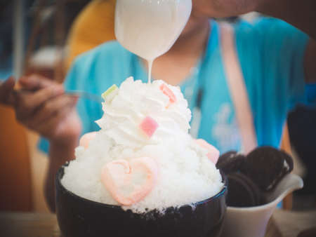 Korean shaved ice dessert with the child poured condensed milkの写真素材