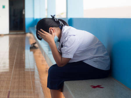 Asian young girl student sitting alone with sad feeling at schoolの写真素材