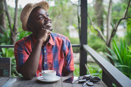 African man thinking with a hot of coffeeの写真素材