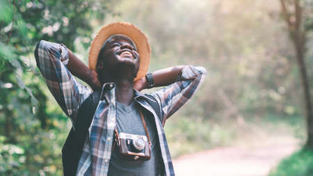 Happiness African man traveler with backpack standing and relaxing freedom in the forest.16:9 styleの写真素材
