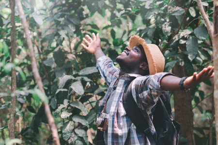 Happiness African man traveler with backpack walking  in the forestの写真素材
