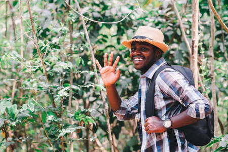 Happiness African man traveler with backpack walking  in the forestの写真素材