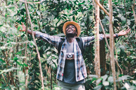 Happiness African man traveler with backpack walking  in the forestの写真素材