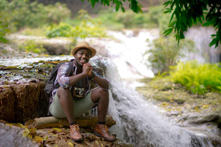 African traveler man sitting and relaxing freedom with waterfallの写真素材